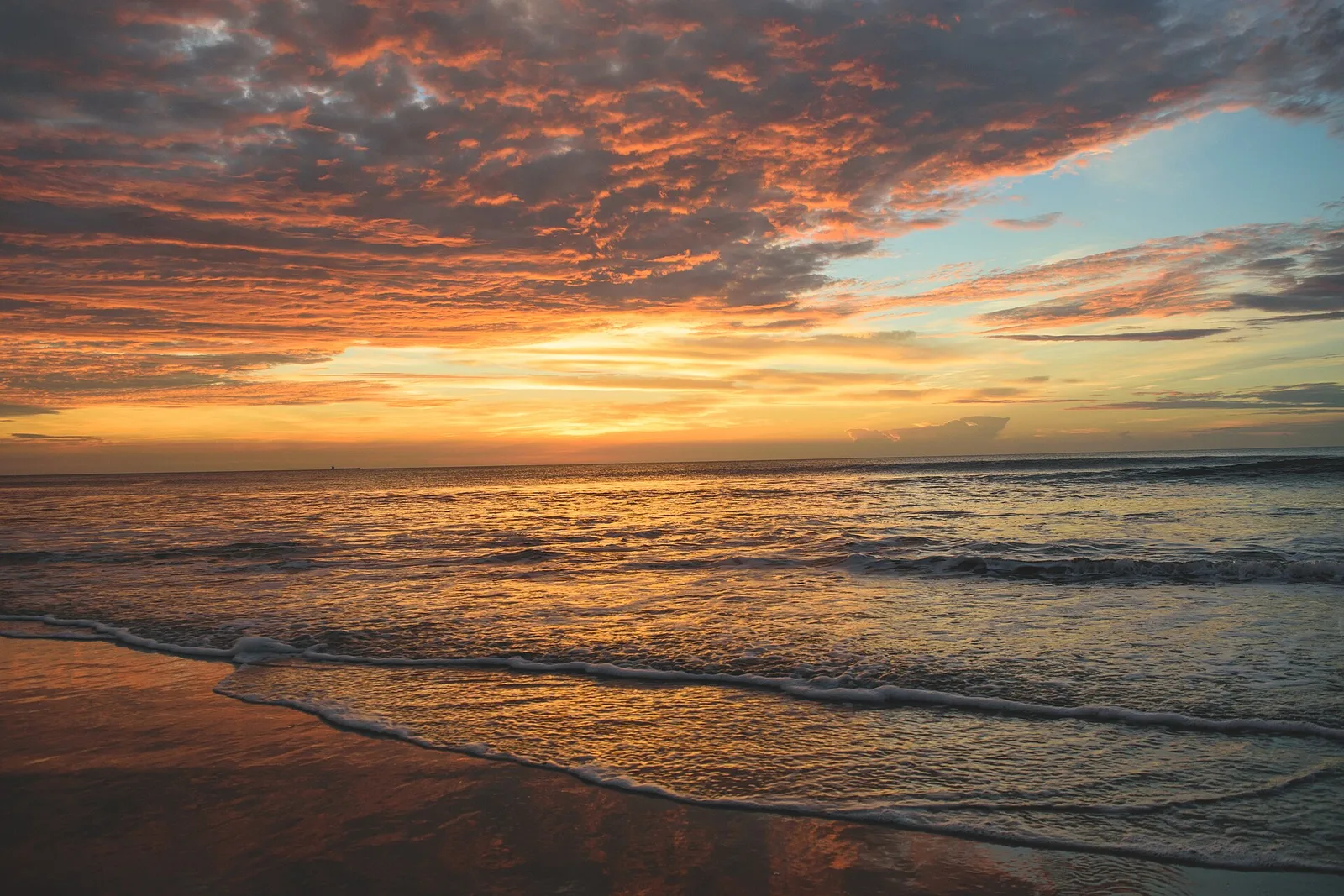 The sun low over the Atlantic Ocean, seen from the beach at the Virginia Beach Oceanfront.