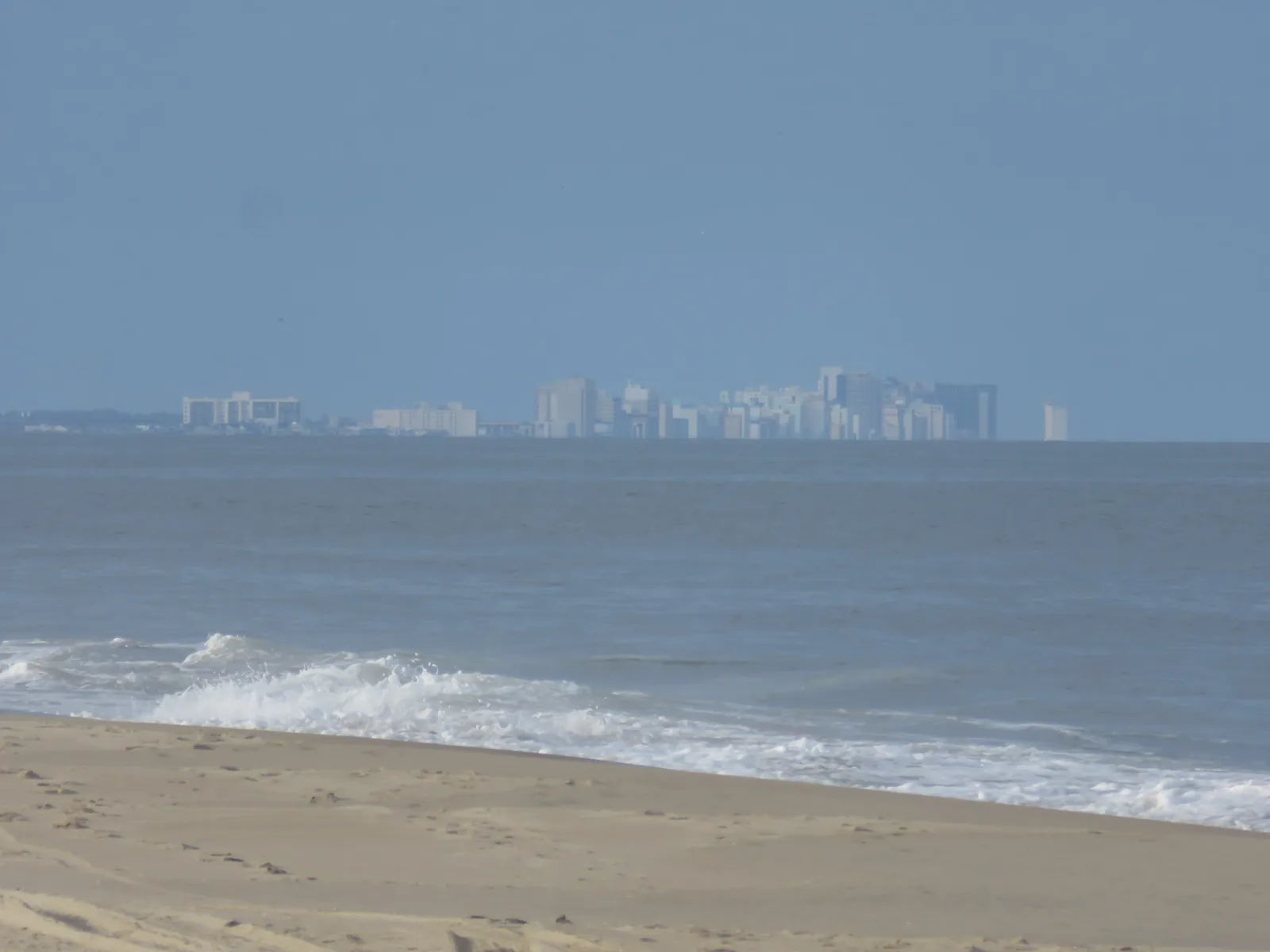 The Virginia Beach Oceanfront skyline seen across the water from the beach at Back Bay National Wildlife Refuge.