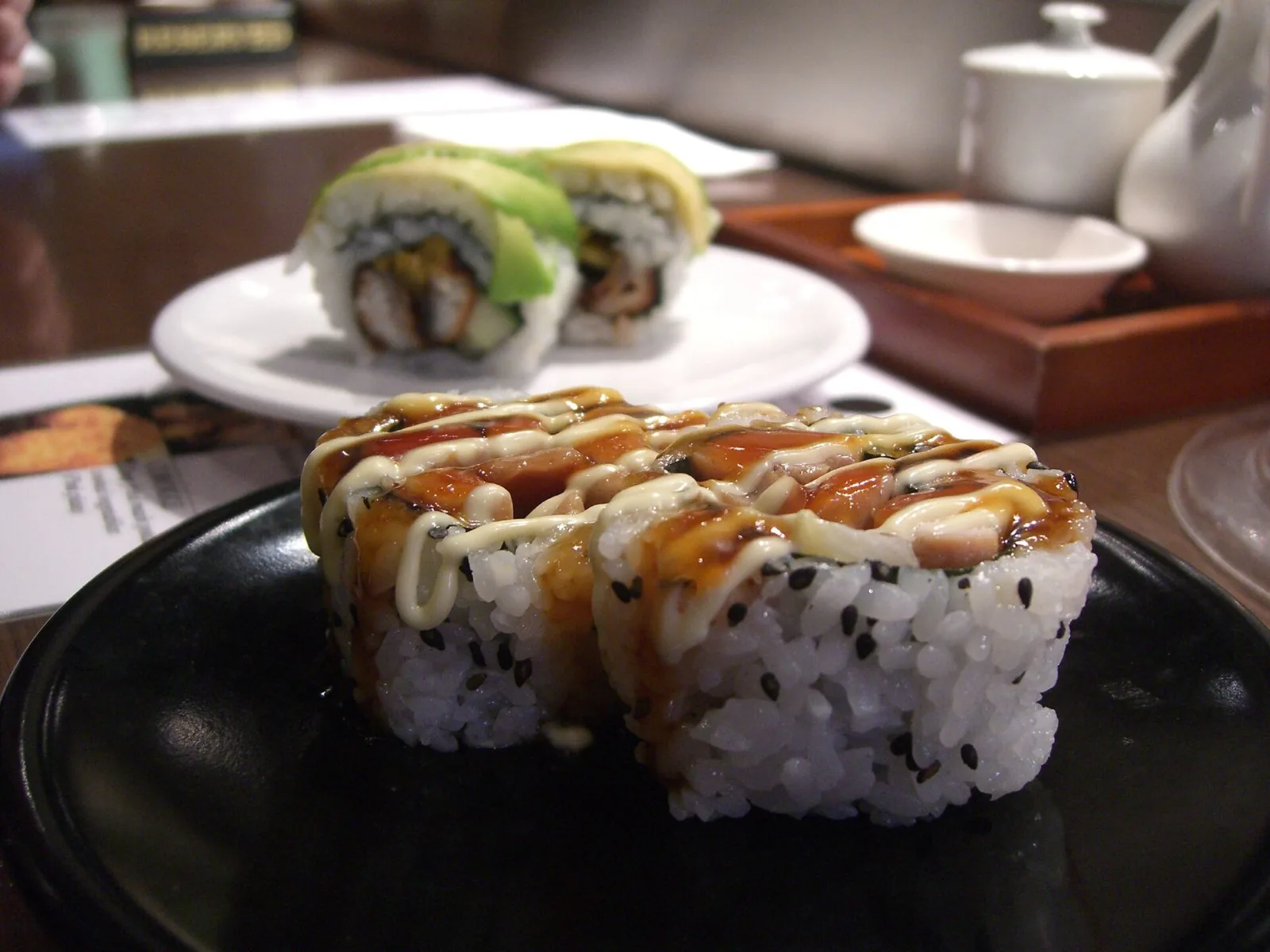 Teriyaki chicken and tempura prawn sushi rolls at a conveyor-belt sushi restaurant in Melbourne, Australia.